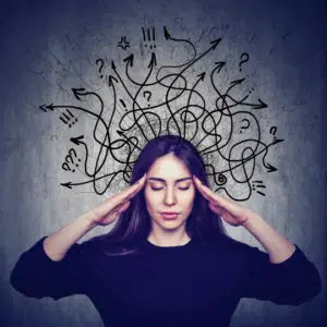 women with hand to temple and drawings behind her with lots of doodles indicating a busy thought life