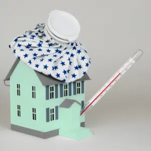 green toy house with thermometer in the front door and cooling pack on the roof showing quarantine and lockdown