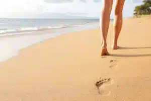 woman walking barefoot on the beach