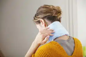 woman with warm pack on her neck