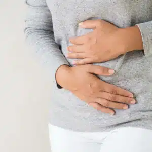 Women holding stomach - bloating