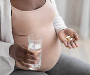 Prenatal vitamins for PCOS pregnant woman holding vitamins in her hand