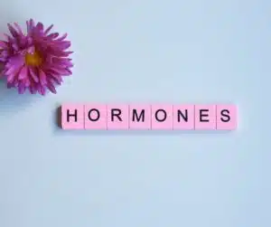 blue background with pink scrabble tiles spelling "hormones"